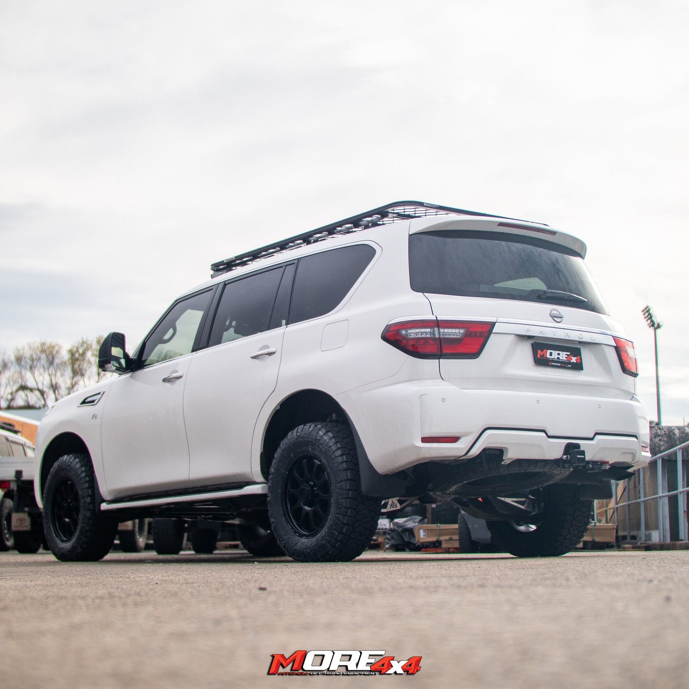 White SUV with roof rack on a paved surface, featuring 'MORE 4x4' branding.