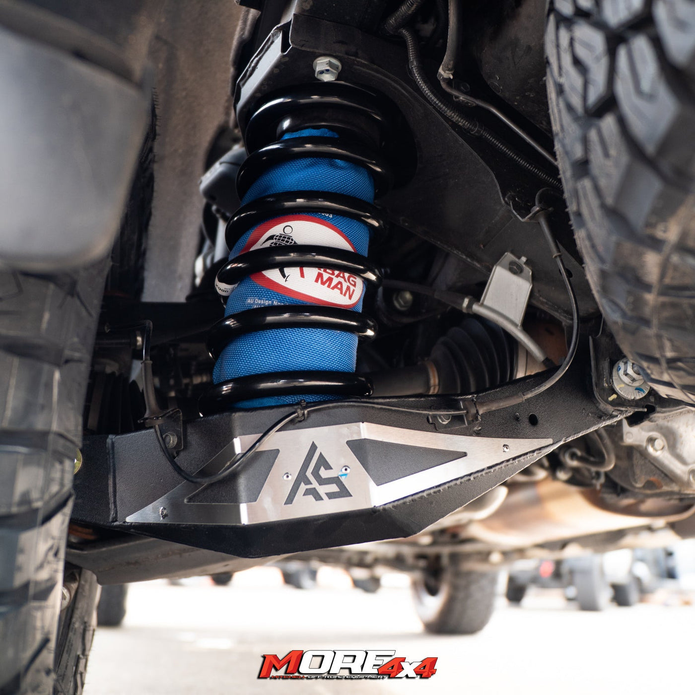 Close-up of a vehicle's suspension system with blue shock absorbers and visible branding.